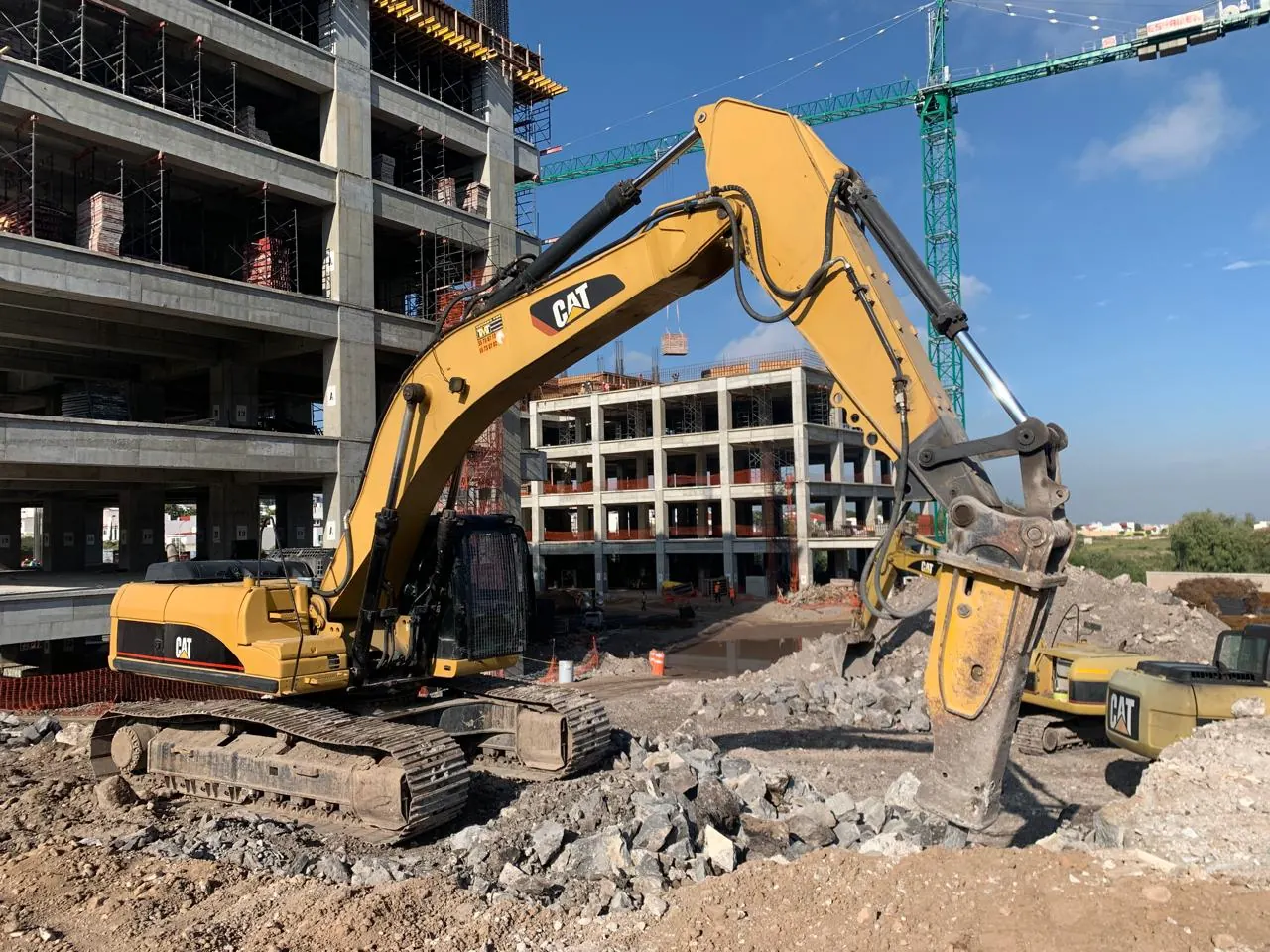 Excavadora Caterpillar con martillo hidráulico trabajando en construcción