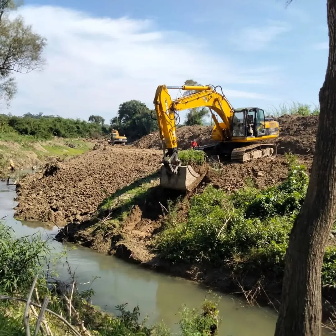 Excavadora hidráulica trabajando junto a un canal