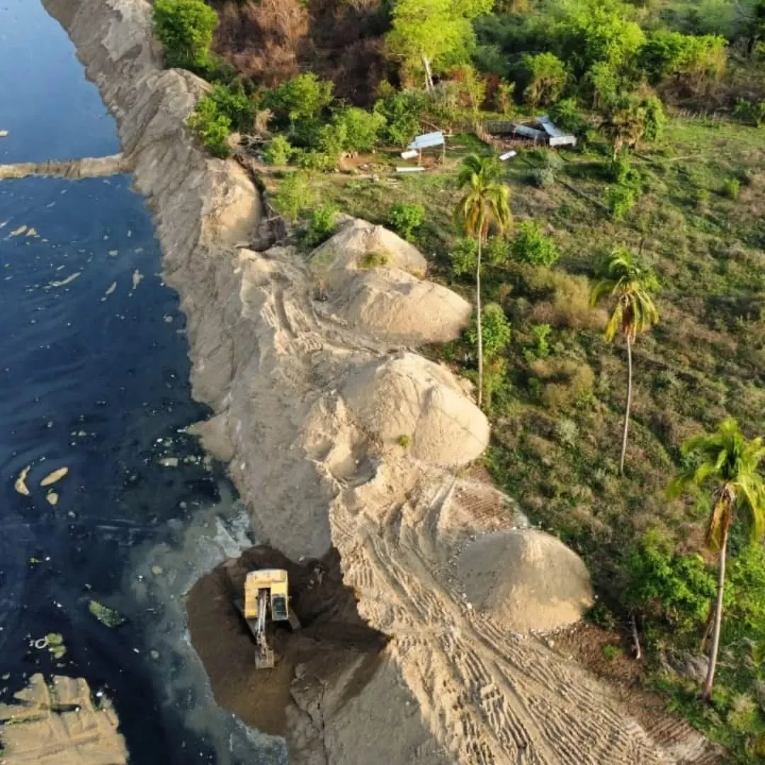 Excavadora trabajando en movimiento de tierra junto al agua