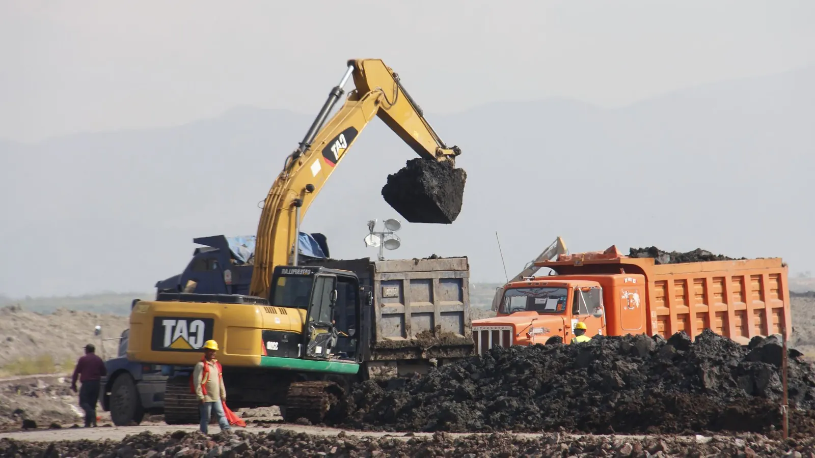 Excavadora Caterpillar 740 cargando material en camiones de obra