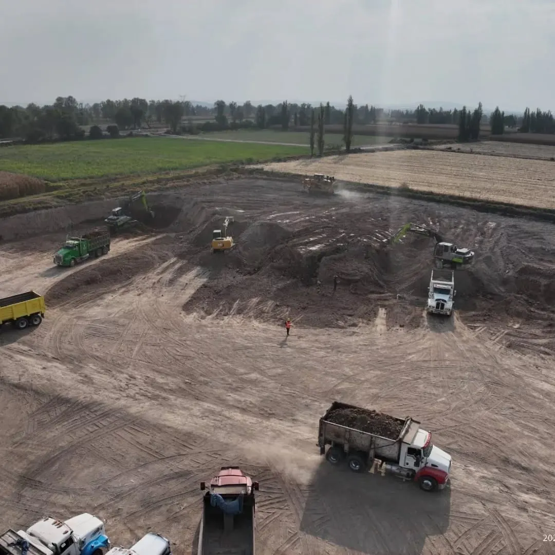 Vista aérea de excavadoras y camiones trabajando en terracería